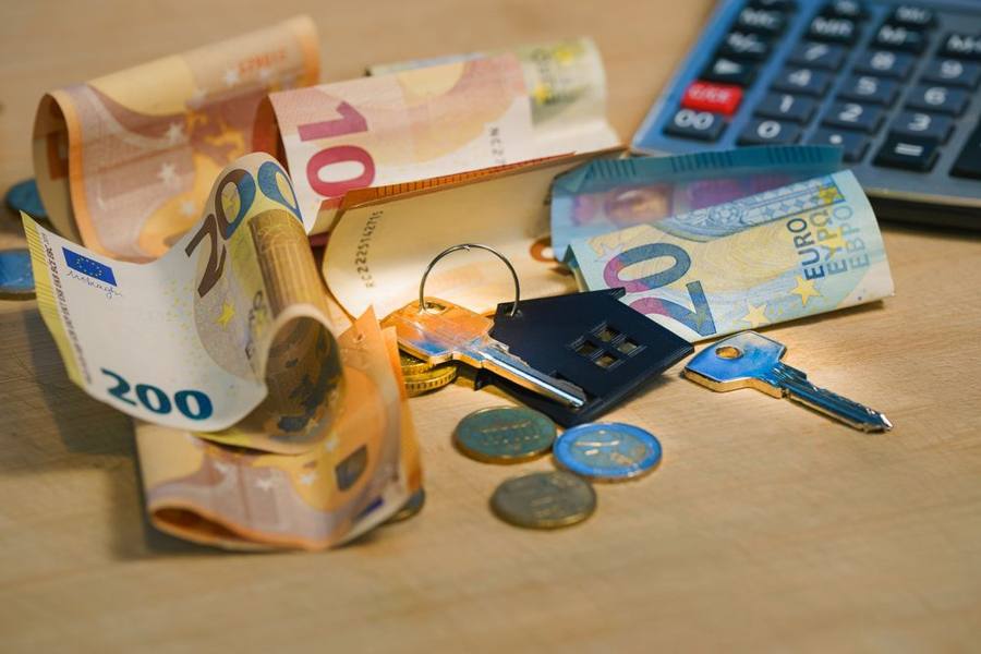 Modellino di casa con monete e calcolatrice: agevolazioni fiscali